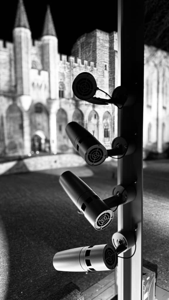 Rampe de projecteurs à gobo installée sur mat, façade du Palais des Papes d'Avignon en arrière-plan.