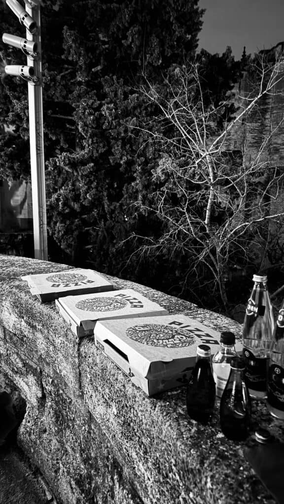 Trois boîtes de pizzas posées sur parapet pendant le chantier nocturne du Palais des Papes d'Avignon.