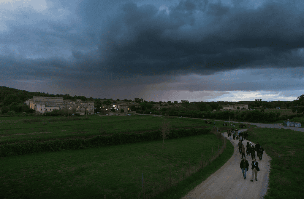 Le groupe de concepteurs lumière marche au crépuscule vers Monteriggioni, workshop Going Dark 2024