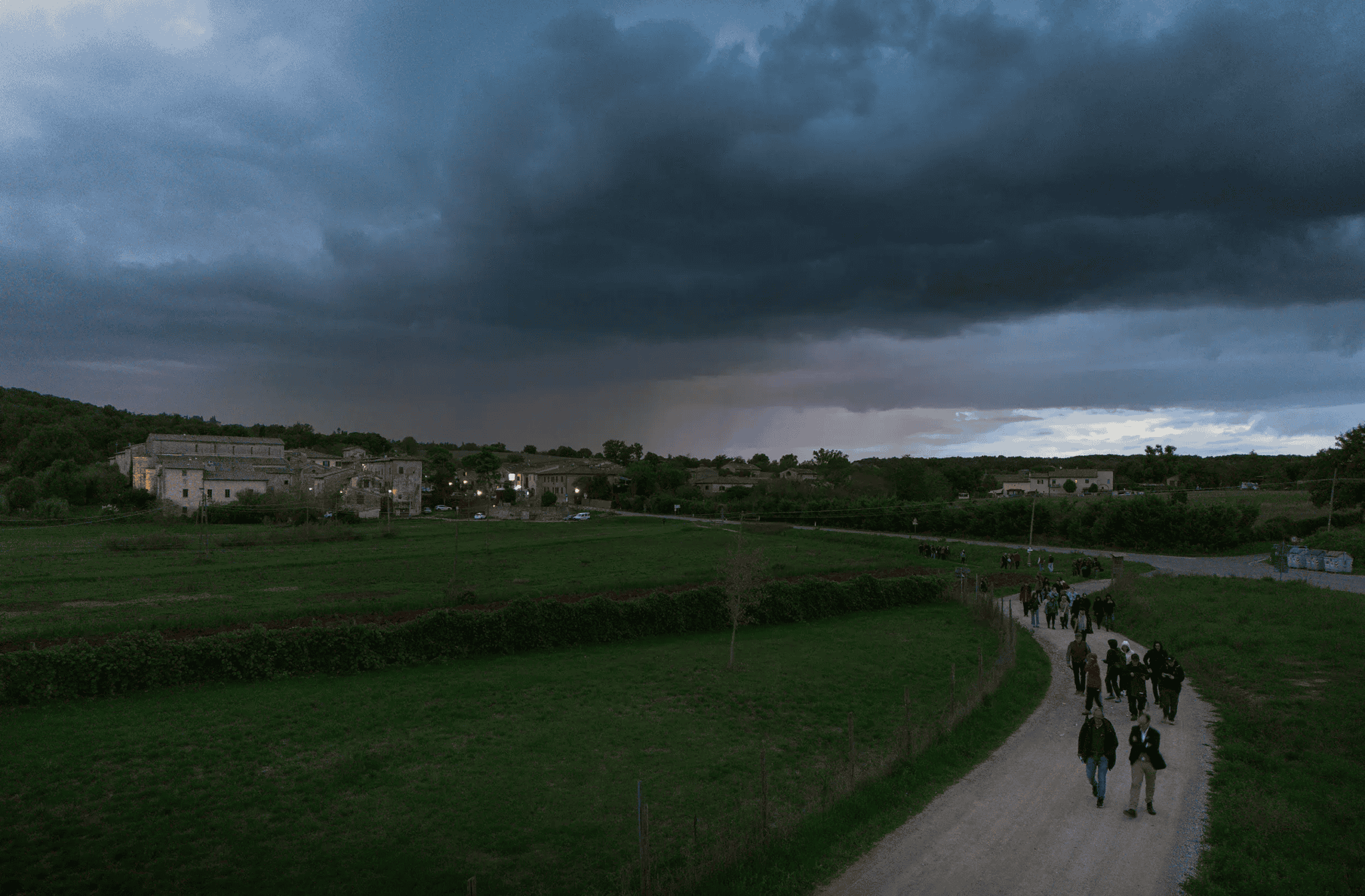 Le groupe de concepteurs lumière marche au crépuscule vers Monteriggioni, workshop Going Dark 2024