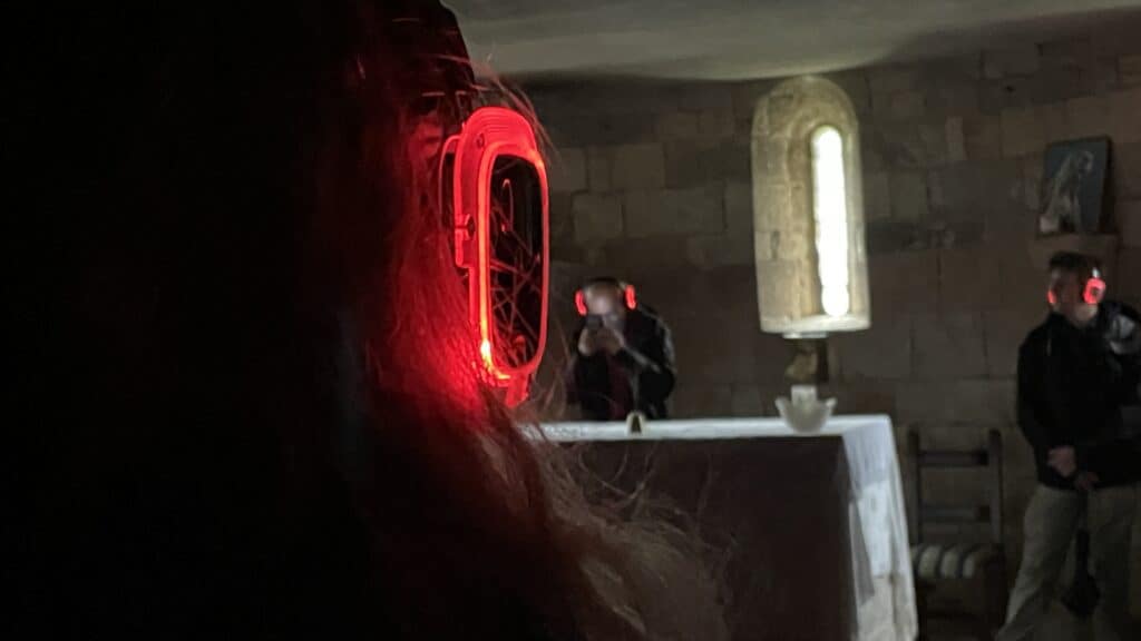 Gros plan sur un casque rouge luminescent, abside en arrière-plan, Silent Play Going Dark 2024