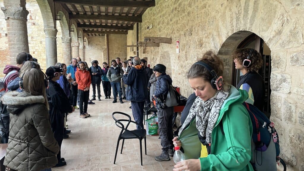 Participants avec casques audio sous les arcades du cloître, Silent Play de La Piccionaia, Going Dark 2024