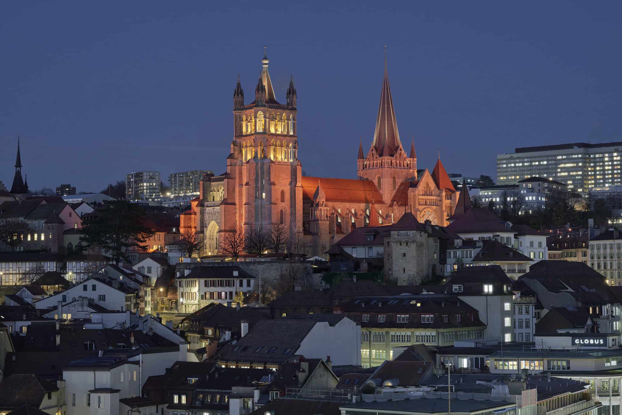Cathédrale de Lausanne depuis le sud, lumière ambrée au crépuscule hivernal H1, conception L'Acte Lumière.